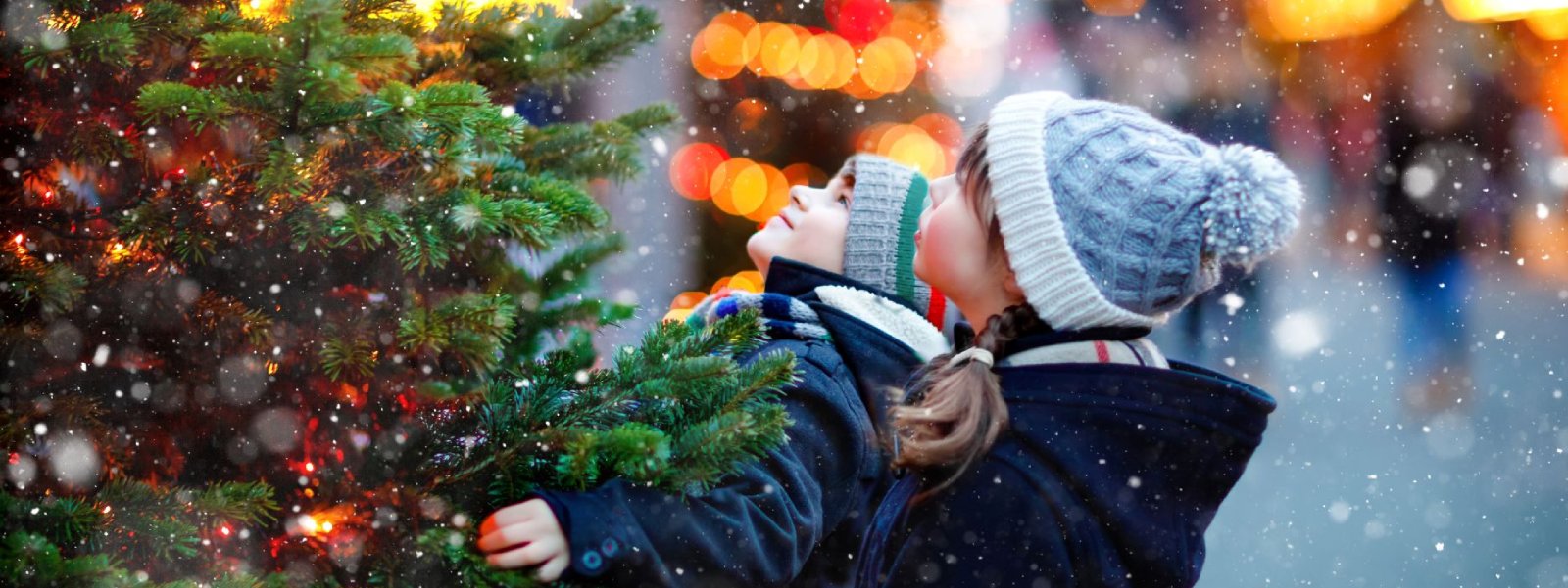 Two children around a Christmas tree.